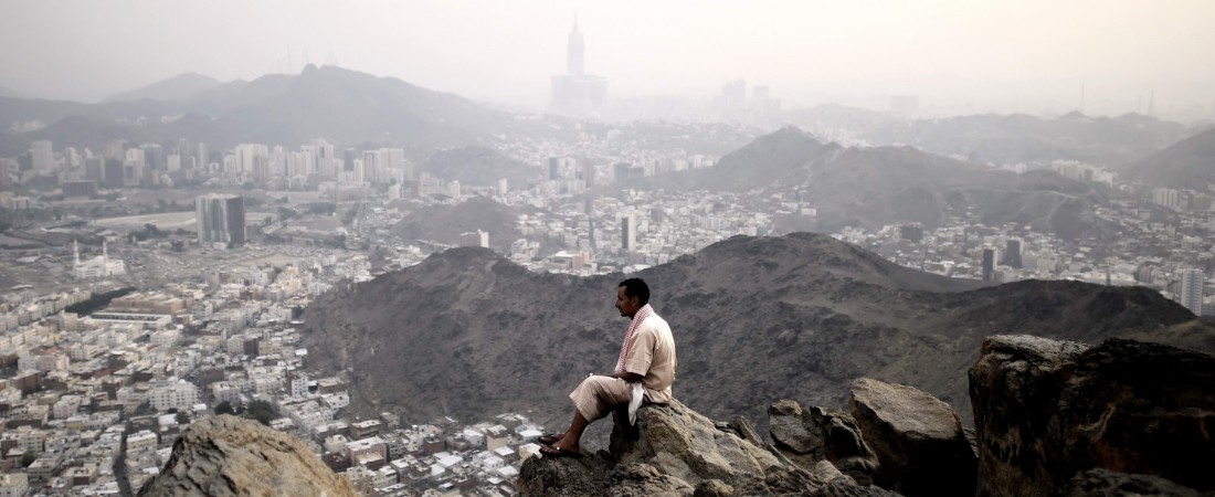 A Muslim pilgrim looks at Mecca from the top of Noor mountain where the Hiraa cave is located on September 19, 2015 as more than a million Muslims from around the world converge the holy city of Mecca for the annual hajj pilgrimage. According to tradition, Islam's Prophet Mohammed received his first message to preach Islam while praying in the cave.  AFP PHOTO / MOHAMMED AL-SHAIKH